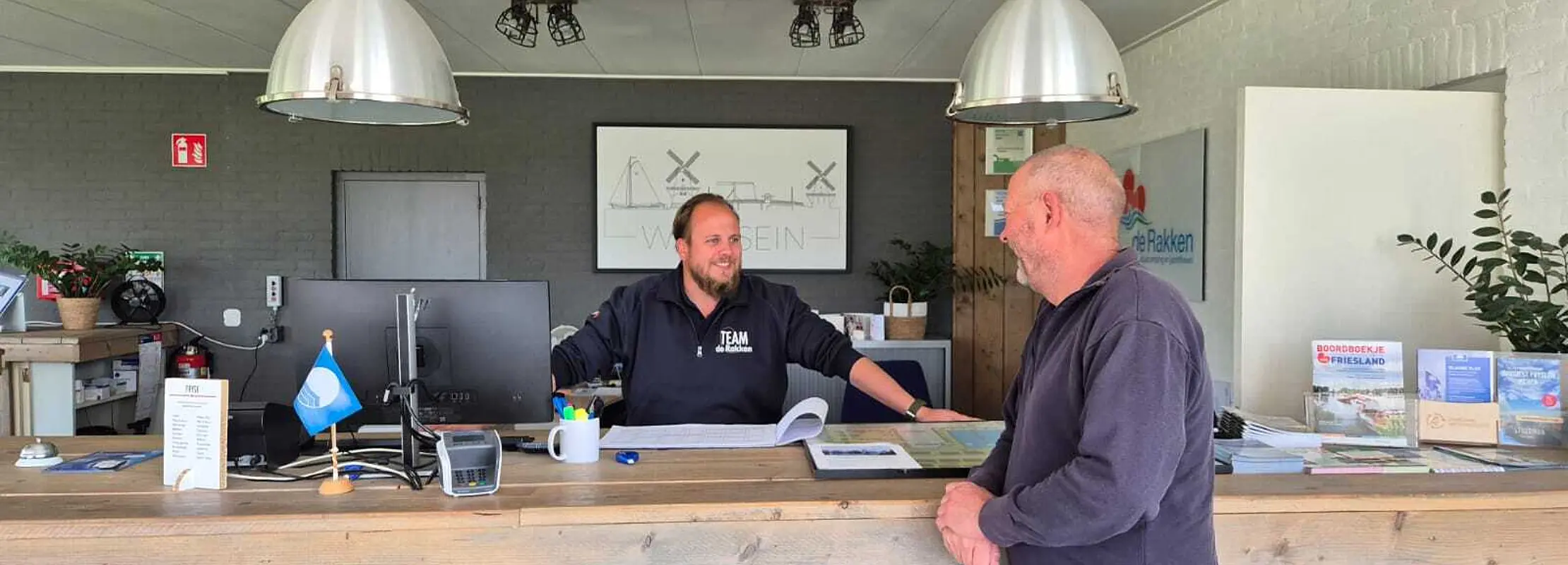Axl achter de balie van de receptie