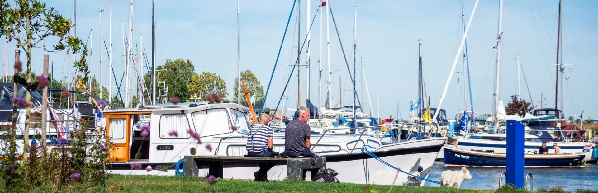 Twee mensen op een bankje bij Jachthaven de Rakken