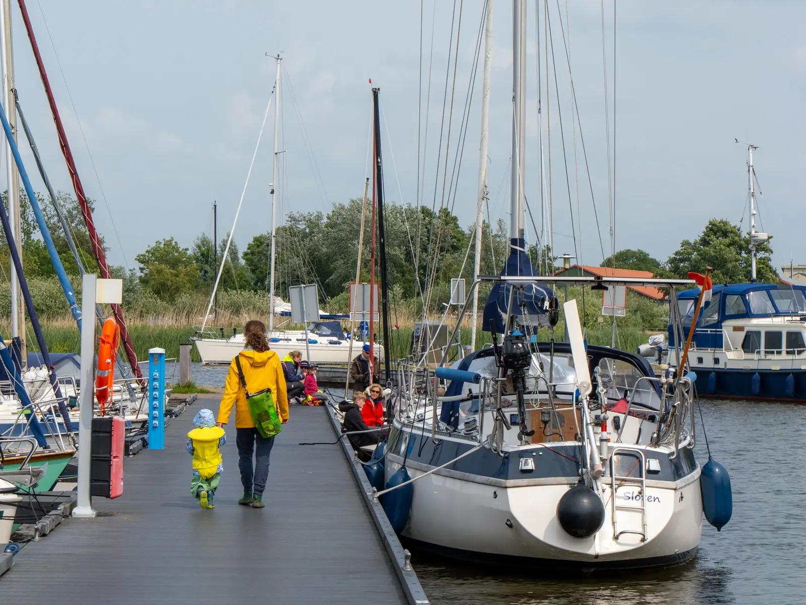 Vrouw en kindje lopen over de steiger van Jachthaven de Rakken