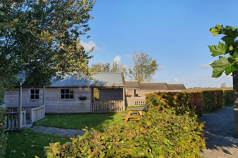 Knusse trekkershut in de herfst in Friesland aan het water